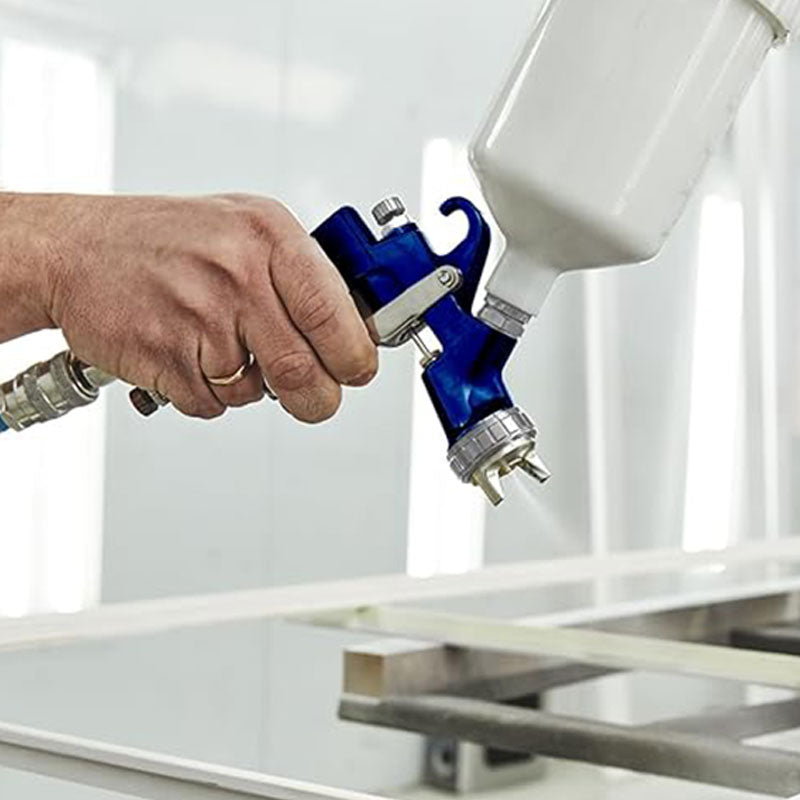 Person using a spray gun to paint a metal surface